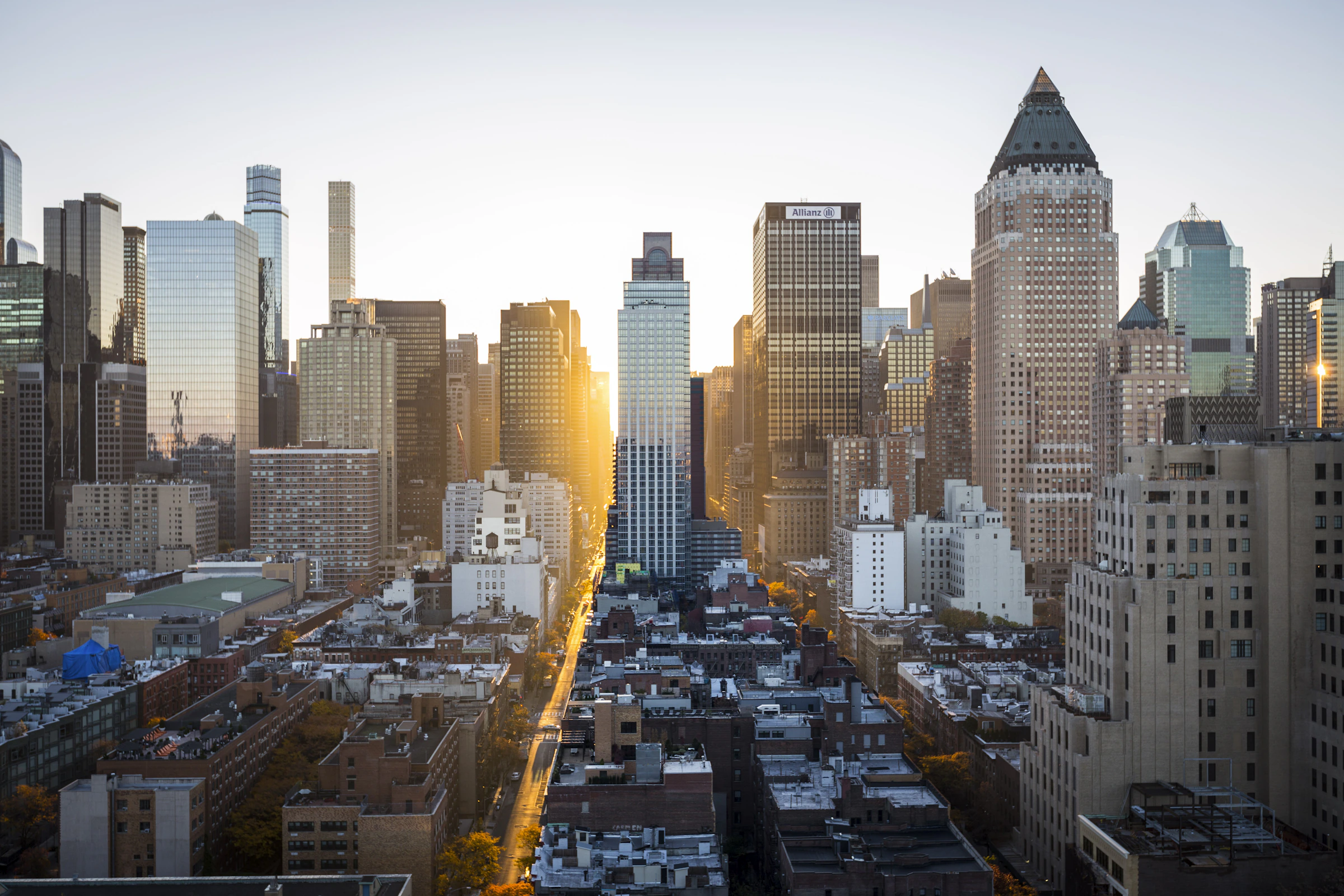 Dense New York City skyline with glass and masonry towers under a clear sky — elevated urban perspective suited to institutional brokerage contexts